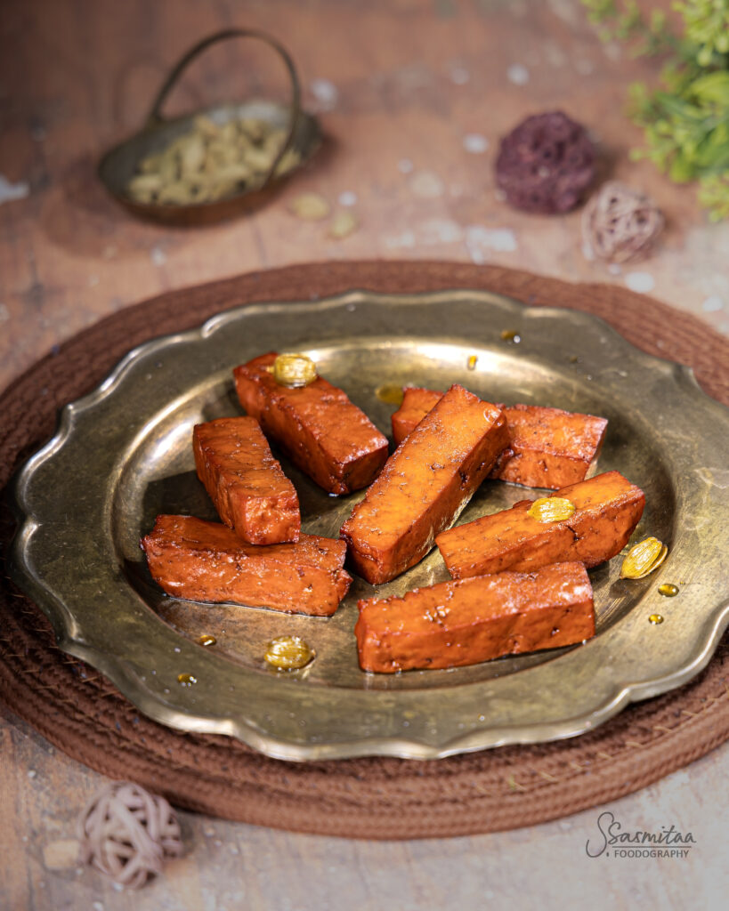 Rectangular chhena sticks coated with sugar and arranged on a serving plate